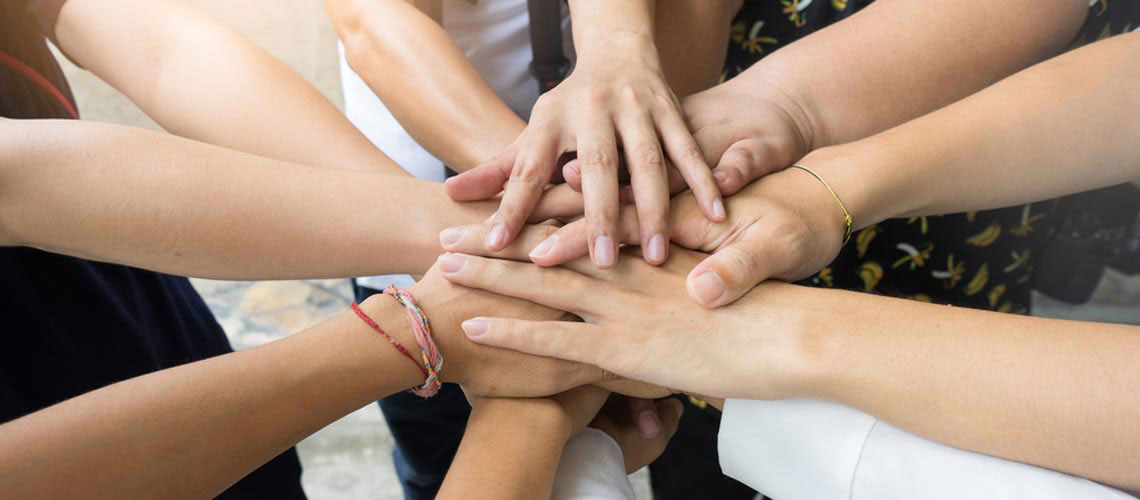 Die Hände von 5 Frauen sind zu sehen, alle Hände liegen übereinander